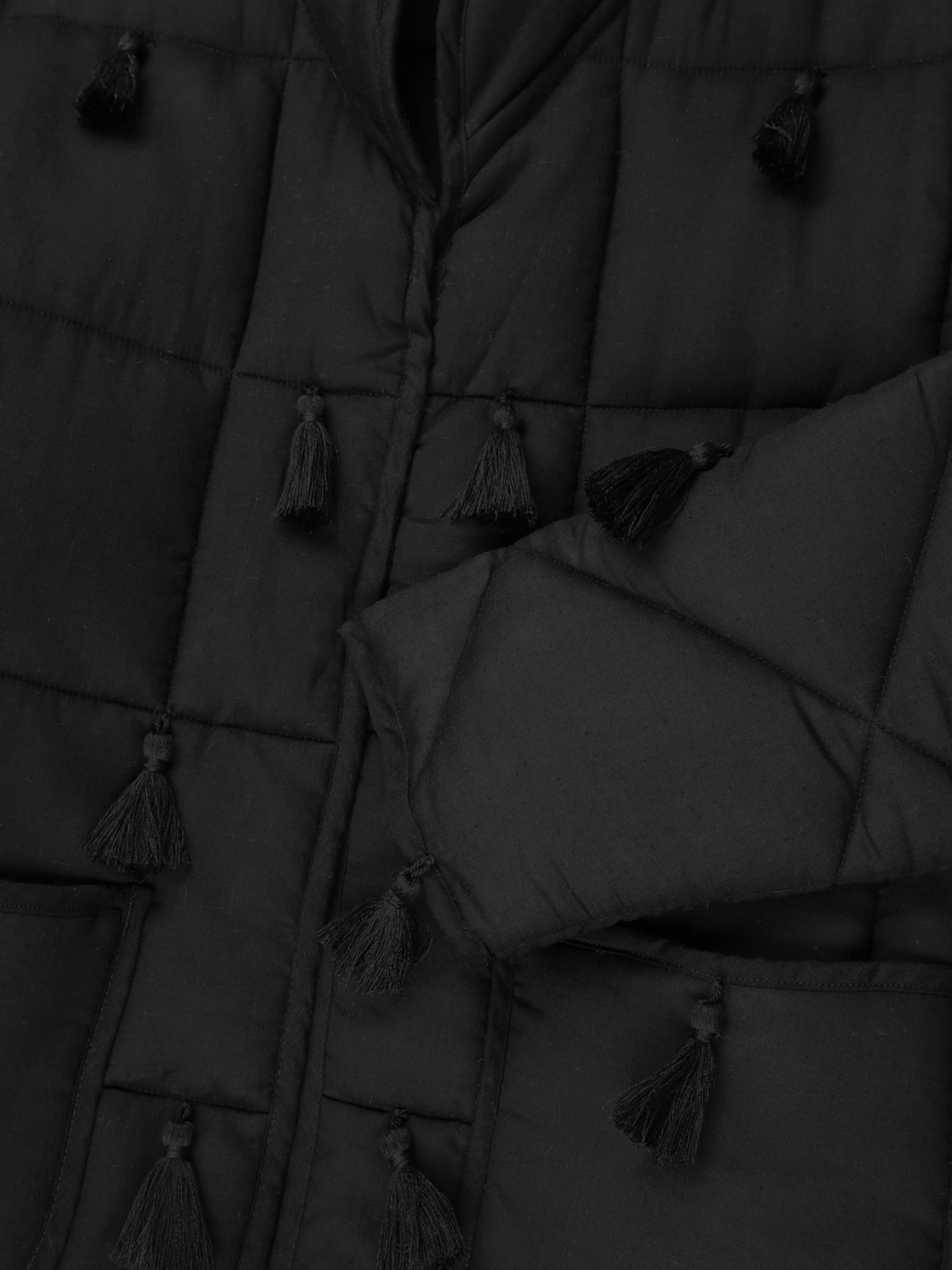 Black Dromen Tassel Jacket fabric detail back with tassel details on a light gray background
