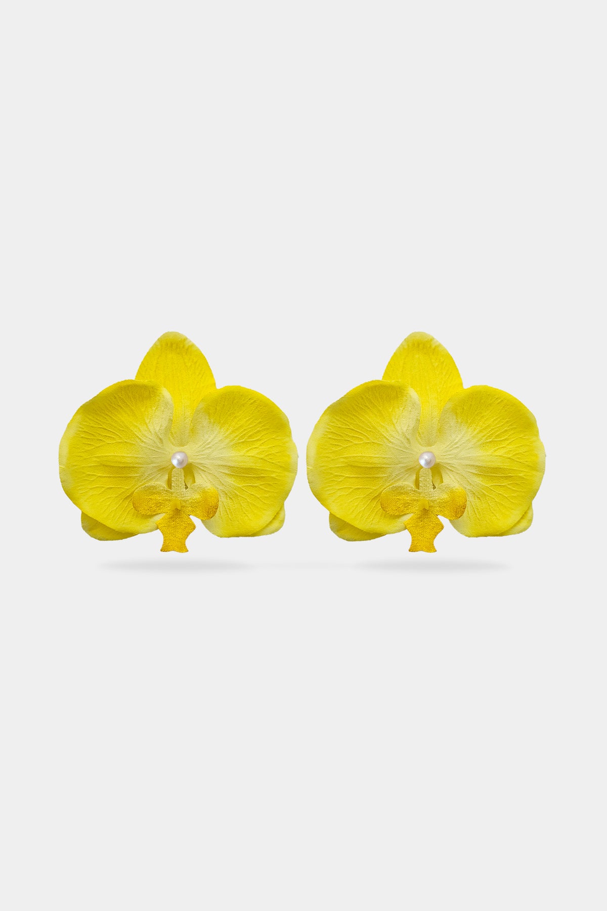A pair of bright yellow orchid flower earrings with pearl look center on a light gray background.