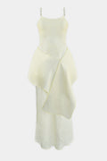 A pale lemon sleeveless dress with thin shoulder straps and beads, a fitted bodice, and an asymmetrical draped overlay, shown against a plain light gray background.