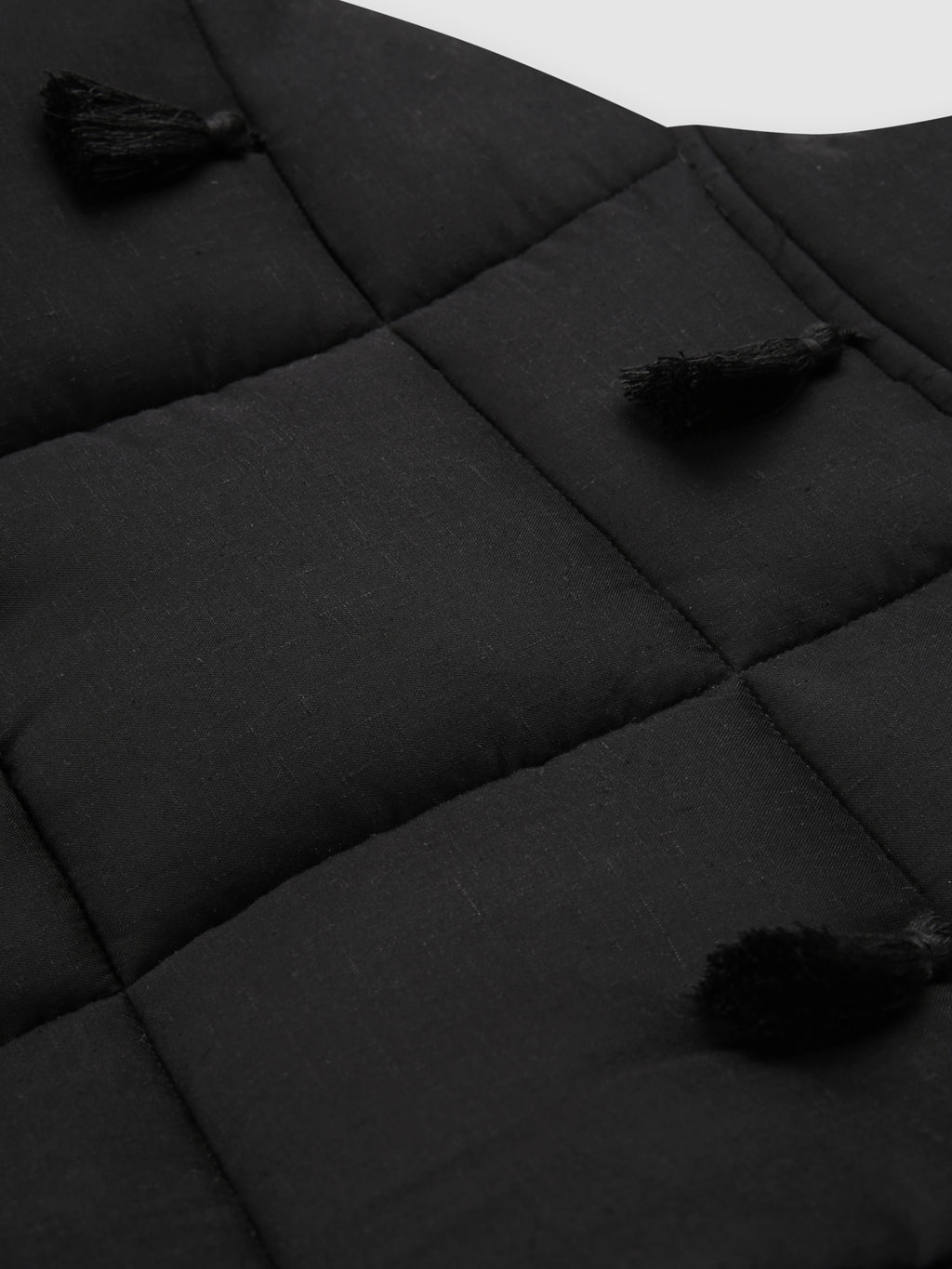 Black Dromen Tassel Jacket back with tassel details on a light gray background