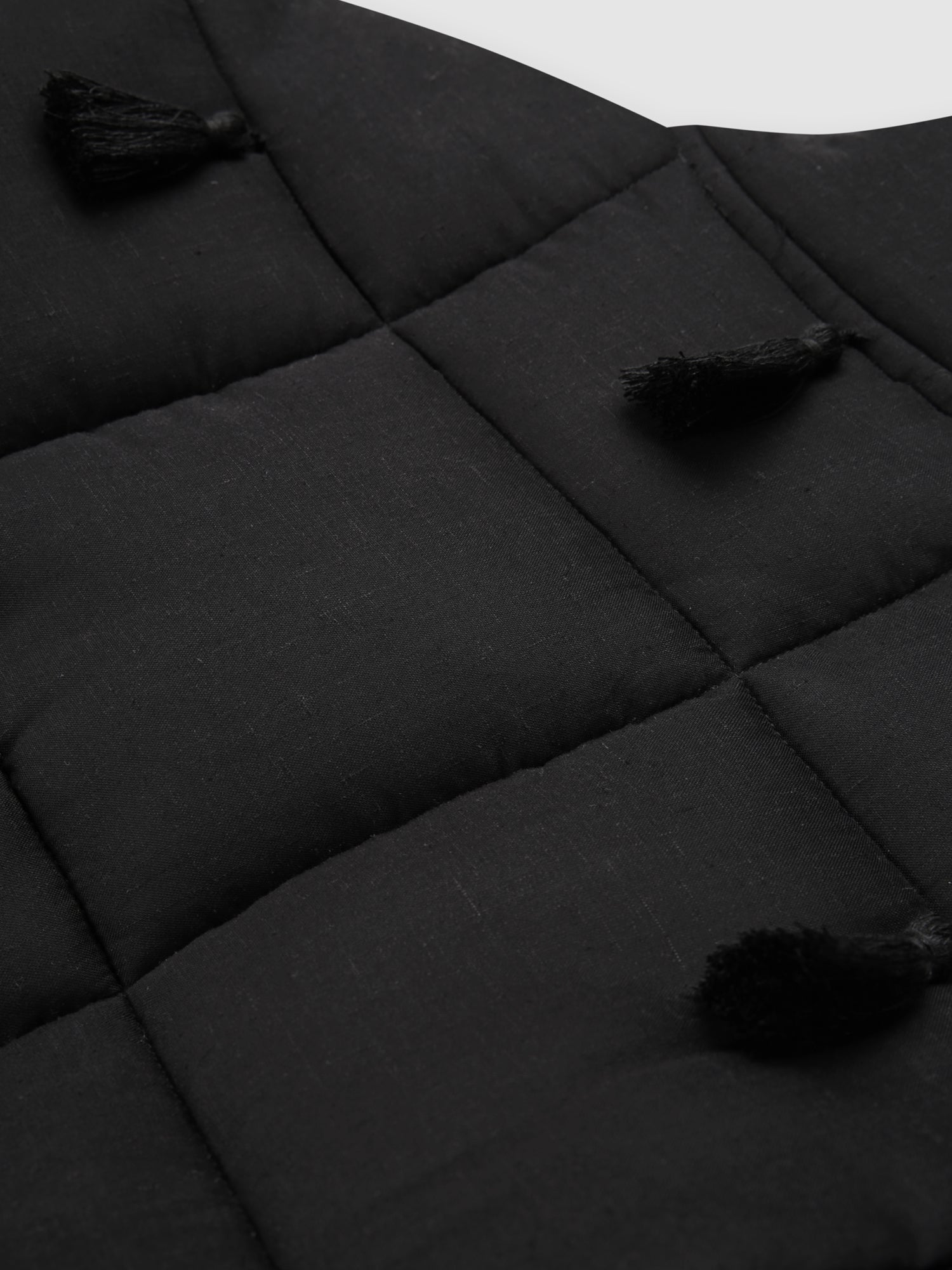 Black Dromen Tassel Jacket back with tassel details on a light gray background